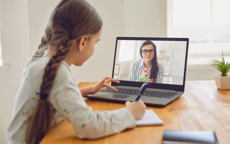 Menina vendo video aula em um notebook