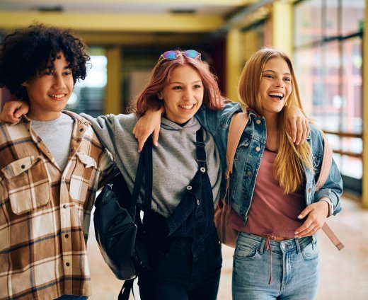 Multiracial,Group,Of,Happy,High,School,Friends,Walking,Through,Hallway